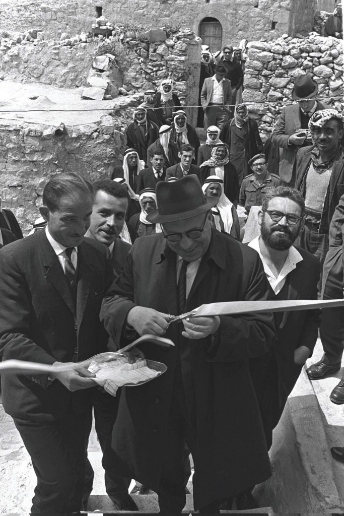 האם תושבי יטא יכולים להצטרף לציבור הישראלי כיהודים? נראה שכבר איחרנו את המועד. שר הסעד יוסף בורג ופקיד הסעד ג'מיל דהבי גוזרים את הסרט בפתיחת סניף המשרד ביטא, 1968 